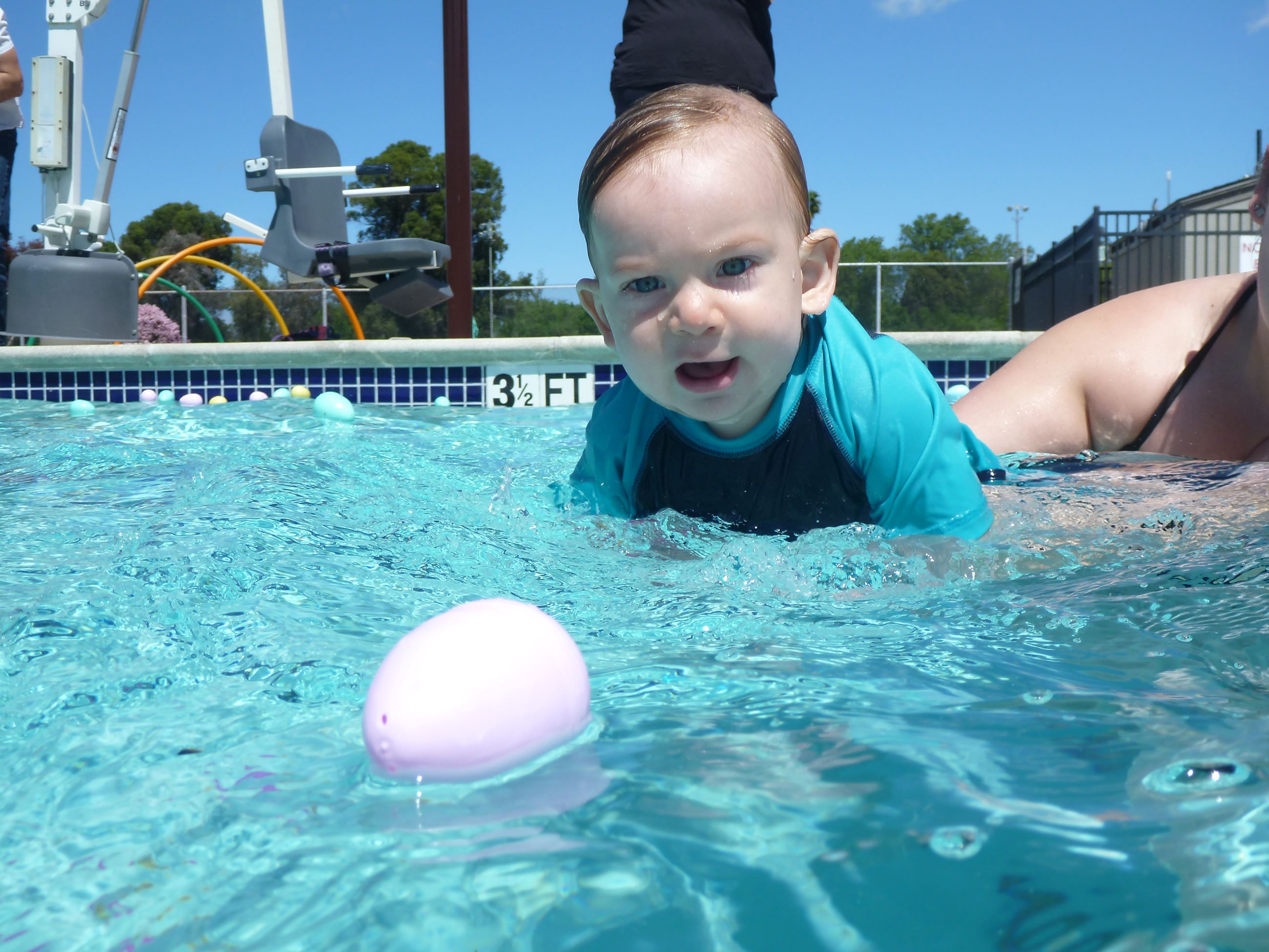 Toddler swimming towards floating egg