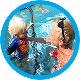 Toddler in water with swim instructor