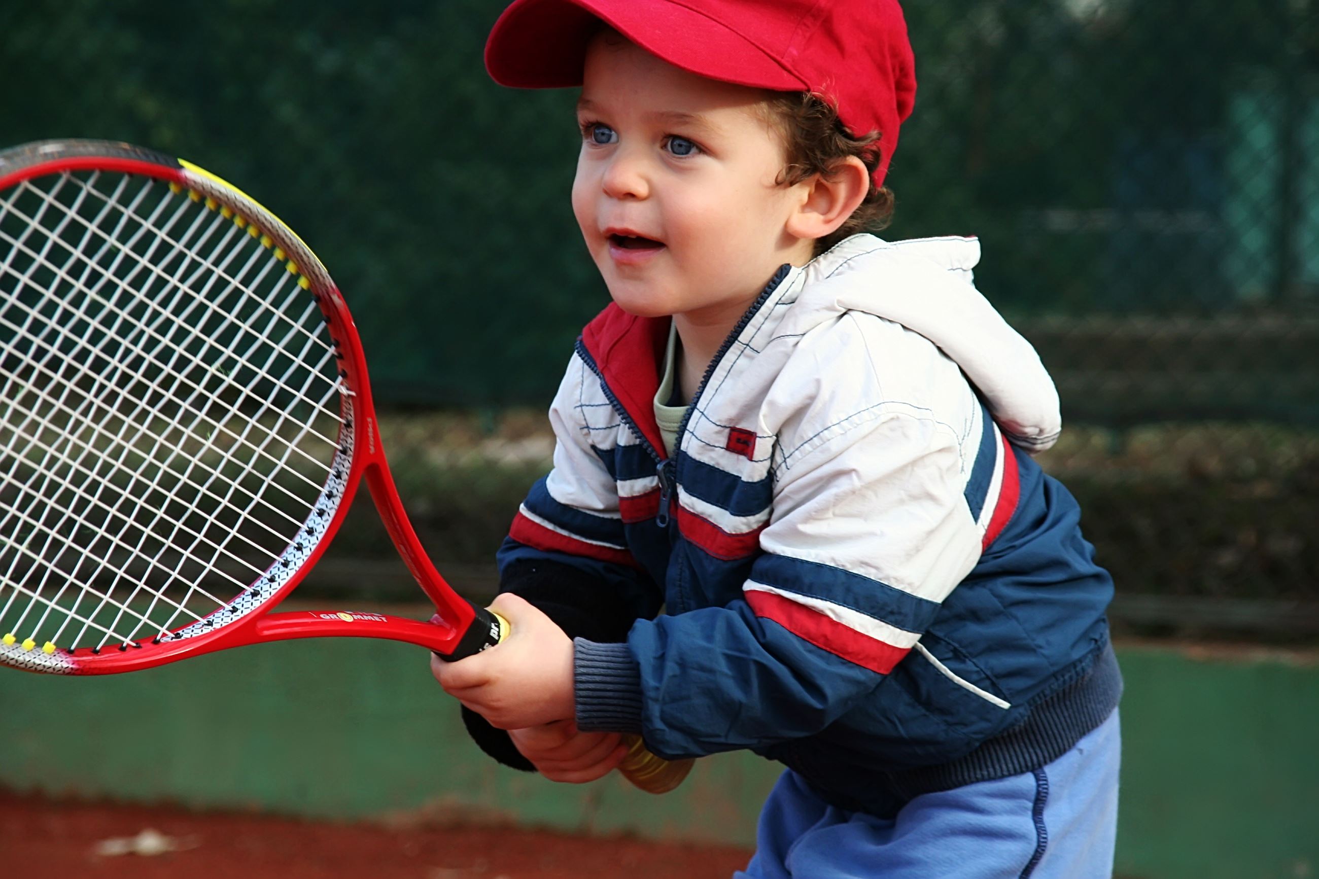Young boy holding tennis racquet 